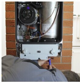 Engineer working on an opened-up boiler during a service